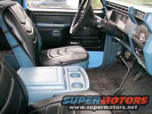 Blue and black interior of a 1980s Ford Bronco with bucket seats and a center console