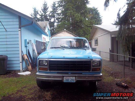 Front view of a light blue Ford Bronco parked in a yard