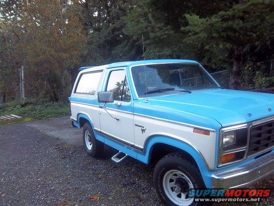 Two-tone blue and white Ford Bronco with chrome trim and running boards