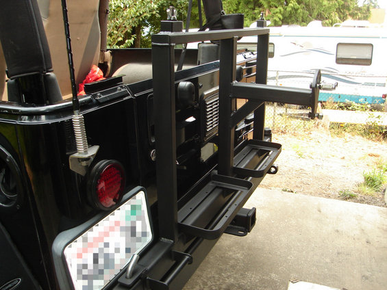 Black rear bumper carrier with spare tire mount and two storage trays