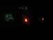 1994 Ford Escort - A blurry nighttime photo shows illuminated vehicle lights against a dark background.