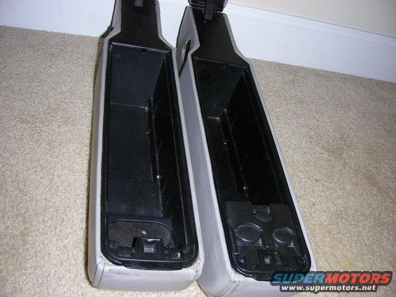 Two car arm rests, one on the left and one on the right, are shown from above. They are light gray on the outside and black on the inside