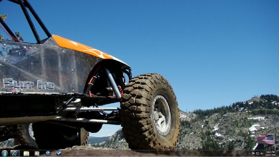 Off-road buggy with orange flame decals and large tires, seen from the front quarter