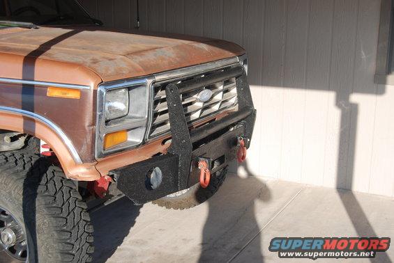 Brown truck front end with aftermarket bumper and winch. Grille has Ford logo