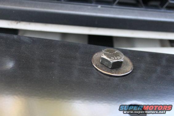 Close-up of a bolt and washer on a black surface