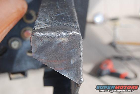 Welded metal bracket with rough welds, close-up view