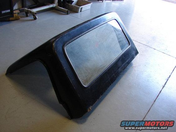 Black Jeep hardtop with a rectangular window, viewed from the side