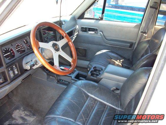 1992 Jeep Cherokee interior showing dashboard, aftermarket wood steering wheel, and leather seats