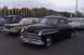 1991 Ford Crown Victoria - Several vintage cars are parked in a lot, including a black coupe with custom pinstriping.