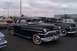 1991 Ford Crown Victoria - A pair of vintage sedans are parked outdoors under a cloudy sky.