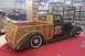 1991 Ford Crown Victoria - A custom woodie pickup truck is displayed indoors with artwork on the walls and other vehicles nearby.