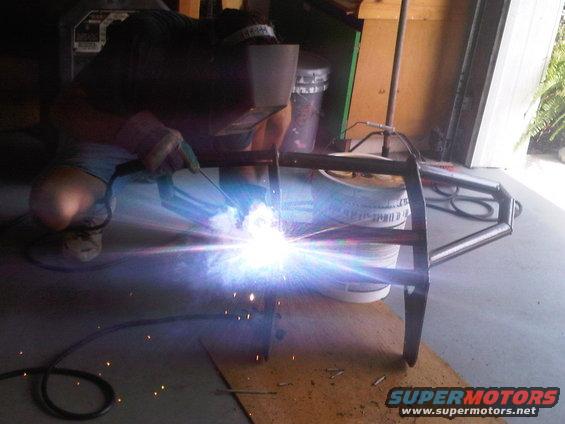 Welding a metal frame, possibly for a motorcycle