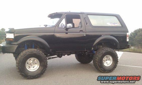 Black SUV with lifted suspension and large tires, side view