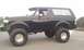 1994 Ford Bronco - This modified SUV features an aggressive stance with oversized wheels and tires, and a raised suspension system.