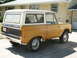 1966 Ford Bronco - This 1966 Ford Bronco is parked in front of a house, showing its side and rear profile.