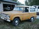 1966 Ford Bronco - A 1966 Ford Bronco is parked outside a garage, with another vehicle visible inside.