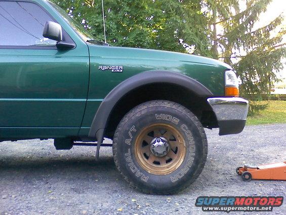 Green 2000 Ford Ranger side view, showing front fender, wheel, and chrome bumper