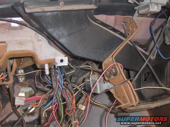 Close-up of a tangled wiring harness and dashboard components inside a vehicle