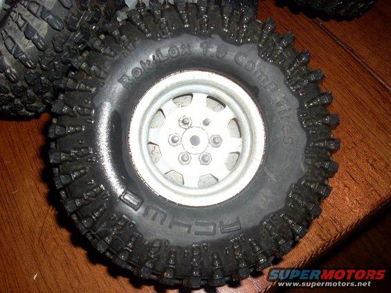 Close-up of an off-road tire with aggressive tread and 'ROKLOX 1.9 Comp Tires' text