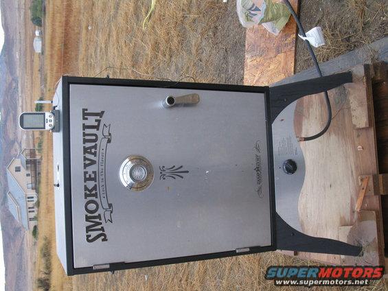 Smoker with "SMOKEVVAULT" logo and a digital thermometer attached