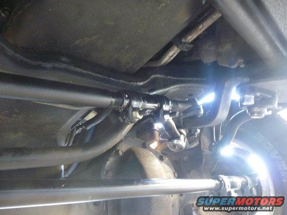 Underside view of vehicle steering linkage and driveshaft components