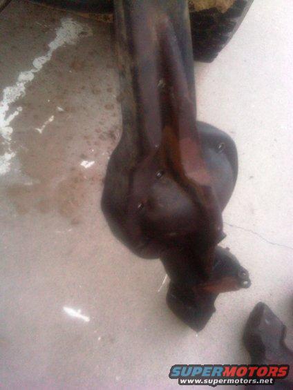 Dark metal automotive suspension part on a concrete surface