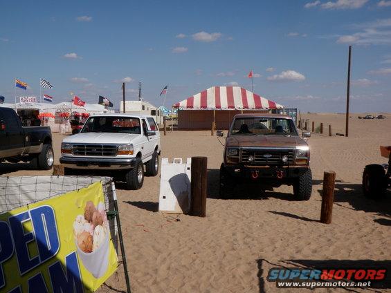 White Ford Bronco with lifted suspension parked on sand
