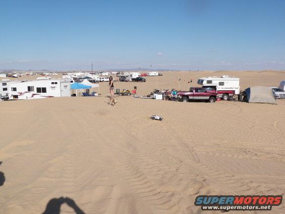Desert campsite with RVs, campers, and trucks under a clear blue sky