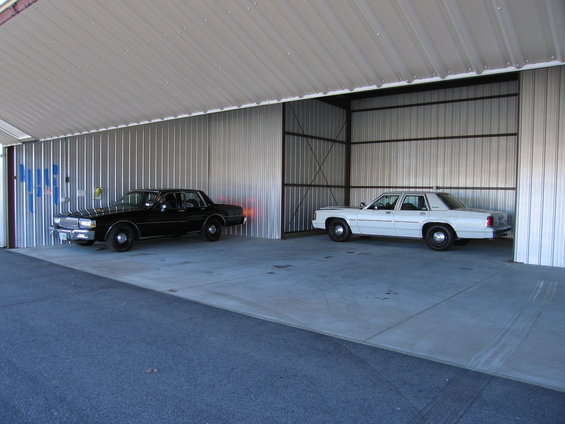 Black and white sedans parked inside a metal structure