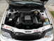 1995 Audi A6 - The engine bay of a white 1995 Audi A6 is shown with the hood open, revealing the V6 engine.