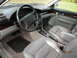 1995 Audi A6 - The interior of a 1995 Audi A6 features light grey leather seats and wood accents on the dashboard and doors.