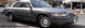 2001 Mercury Grand Marquis - A 2001 Mercury Grand Marquis is shown from the front-right angle, with other vehicles visible in the background.