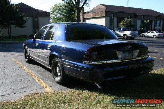 Dark blue 2006 Ford Crown Victoria parked, rear 3/4 view, tinted windows, chrome trim