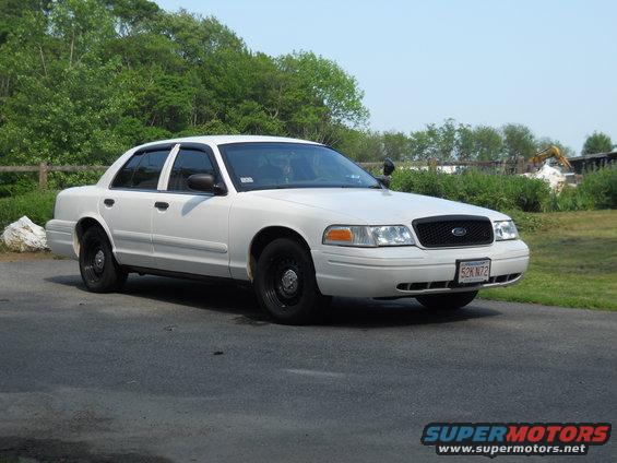 White 2002 Ford Crown Victoria, 3/4 front view. Black grille and steel wheels