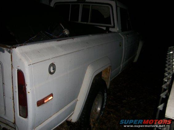 1976 Jeep J-10 pickup truck, rear quarter view, white paint, visible fuel cap