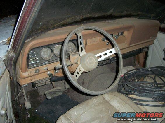 Interior of an old vehicle, showing dashboard, steering wheel, and seats. Lots of coiled cables are on the passenger side