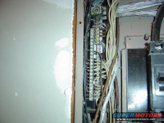 Electrical panel wiring with grounding bar and circuit breakers visible