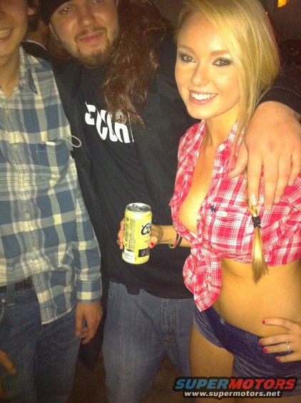 Three people posing for a photo, one holding a beer can