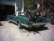 1996 Harley-Davidson Super Glide - A green El Camino is parked outside a garage with a motorcycle loaded in its bed. The vehicle's license plate is visible.