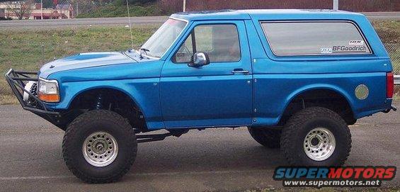 Blue lifted Ford Bronco with aftermarket bumper and BFGoodrich tire sticker on rear window