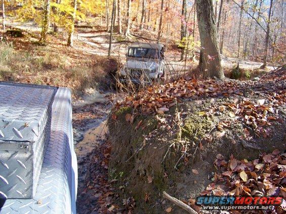Off-road vehicle in mud, viewed from another vehicle's side panel