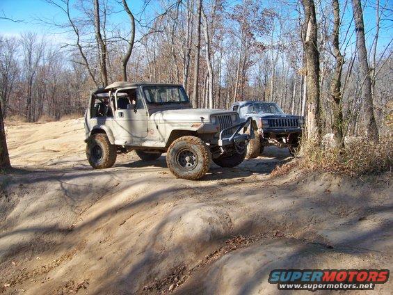 Jeep Wrangler and Jeep Cherokee on a wooded dirt trail