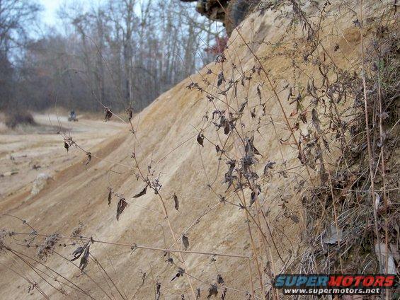 ATV on dirt track with sandy hill and dry brush