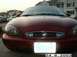 1998 Mercury Sable - The front grille of a red sedan features the Mercury logo, indicating it is a 1998 model.
