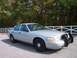 2004 Ford Crown Victoria - This 2004 Ford Crown Victoria, likely a police interceptor model, is shown in a three-quarter front view.