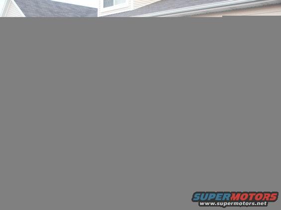 1998 Mercury Sable sedan, rear view, dark color, parked in front of a house