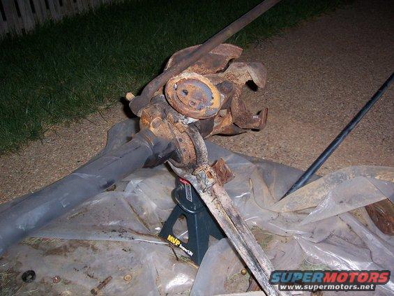 rusted front axle assembly on jack stands