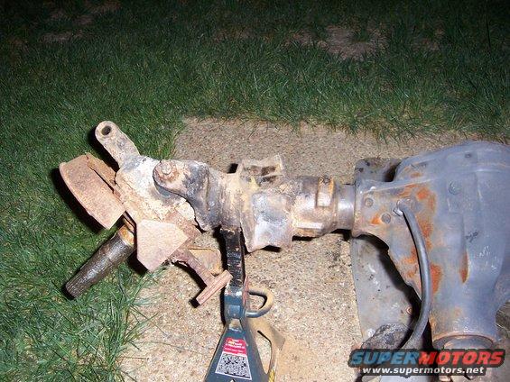 Front axle assembly with brake components and differential housing, resting on jack stands