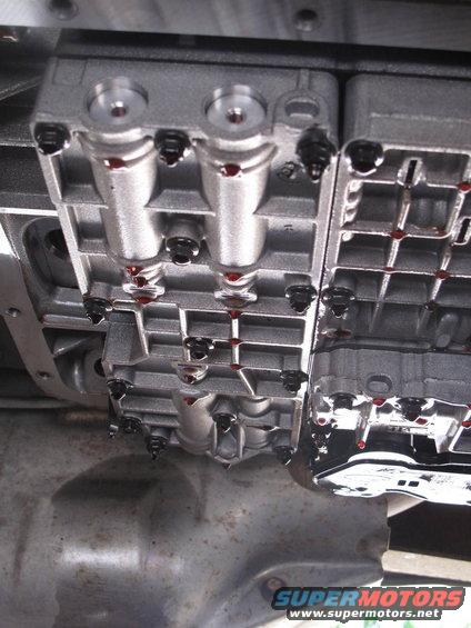 close-up of a transmission valve body with red fluid visible