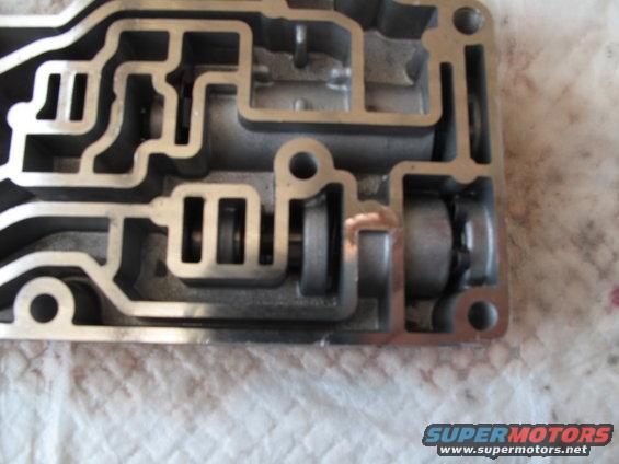 Close-up of an automatic transmission valve body with internal passages and spools